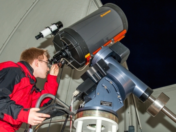 Ein Studierender der Universität Potsdam blickt durch das Teleskop in der Übungssternwarte in die Nachthimmel