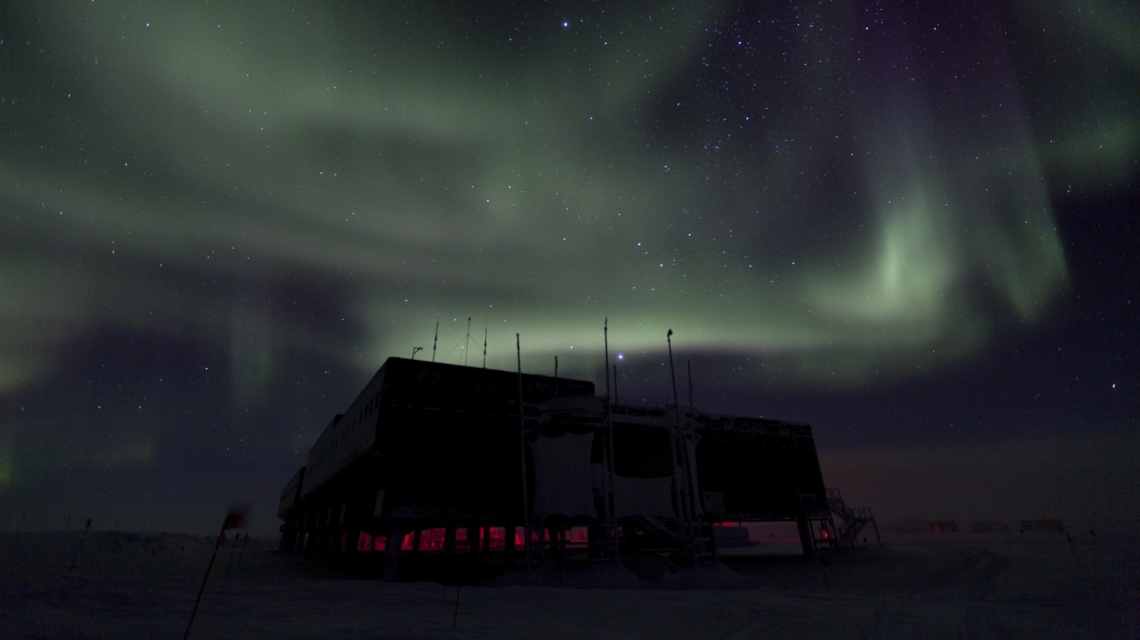 Polar lights over the IceCube laboratory during the polar night, with a starry sky in the background. (Credit: Freija Descamps/NSF, 2011)